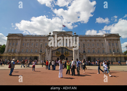 Orizzontale di ampio angolo di turisti al di fuori della parte anteriore del Buckingham Palace scattare fotografie in una giornata di sole. Foto Stock