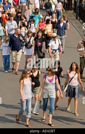 Antenna verticale ravvicinata di una folla di persone - uomini, donne e bambini - a piedi lungo su una luminosa giornata di sole Foto Stock