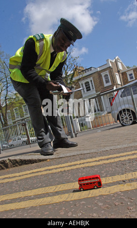 Pic da Howard Barlow TOY LONDON BUS ROSSO parcheggiato su doppie linee di colore giallo Foto Stock