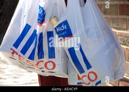 Donna con lo shopping in non degradeable supermercato sacchetti di plastica per essere gradualmente eliminato alcuni negozi addebitando ai clienti per loro Foto Stock