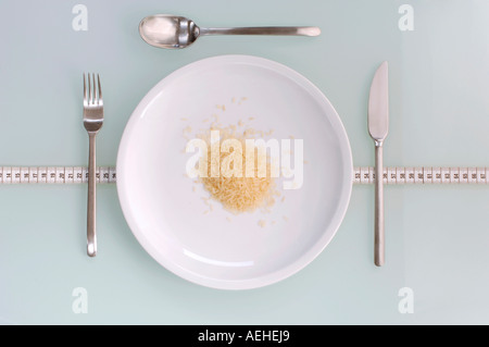 Riso in piastra e posate, close-up, vista in elevazione Foto Stock