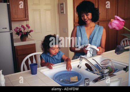 Filipina donna con pre-k ragazza in età prescolare 2-3 anno di età bambino in cucina etnica bi biracial multi diversità razziale la diversità etnica multiculturale culturale Foto Stock