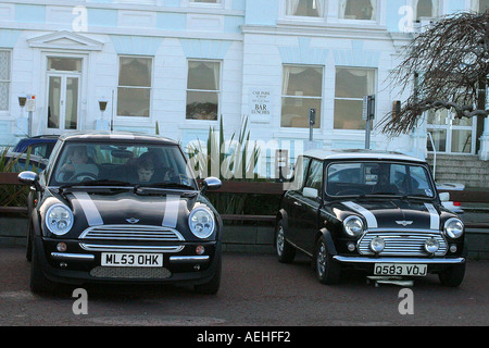 Un nuovo mini da BMW parcheggiato per una simile dipinto classic mini Foto Stock