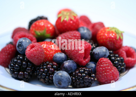 Frutti di bosco su una piastra di un livello degli occhi vicino la vista del paesaggio con uno sfondo semplice Foto Stock