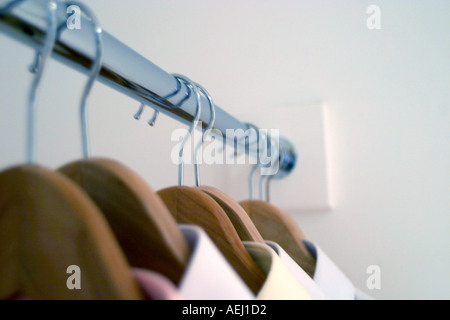 Una fila di magliette appesa in un armadio a muro Foto Stock