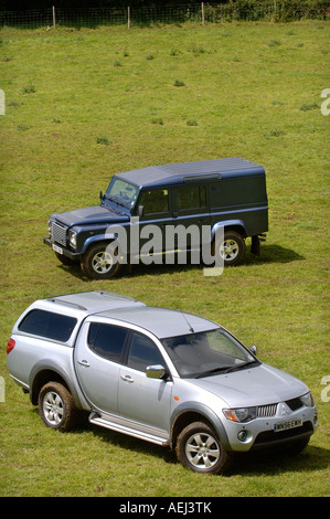 Un Land Rover Defender e Mitsubishi L200 Pick up truck su una pecora GLOUCESTERSHIRE FARM REGNO UNITO Foto Stock