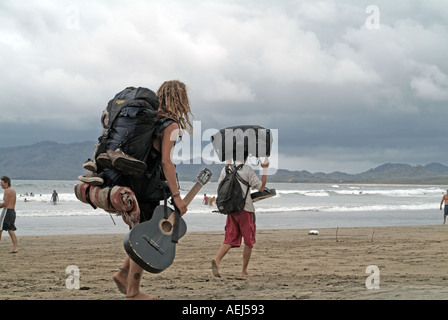 Musicisti camminando sulla spiaggia Tamarindo, Costa Rica Foto Stock