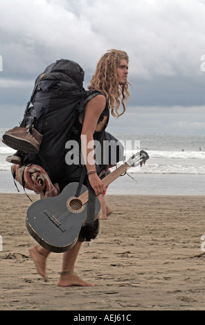 Un musicista camminando sulla spiaggia Tamarindo, Costa Rica Foto Stock