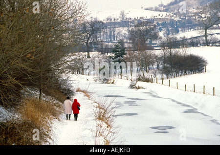 Cheshire Kerridge walkers sul canale a Macclesfield alzaia nella neve inverno Foto Stock