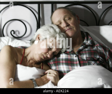 Donna e uomo in anni sessanta a letto addormentato Foto Stock