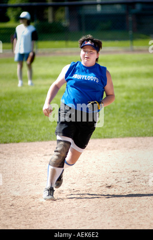 Donna sovrappeso con ginocchio ferito che indossa il tutore corre sul campo da baseball Foto Stock