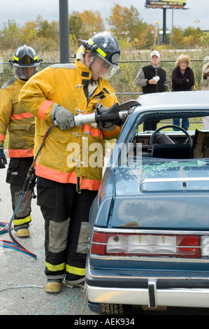 Fireman funziona con le ganasce della vita per estrarre la vittima di incidente automobilistico durante una sessione di formazione Foto Stock