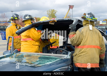Fireman funziona con le ganasce della vita per estrarre la vittima di incidente automobilistico durante una sessione di formazione Foto Stock