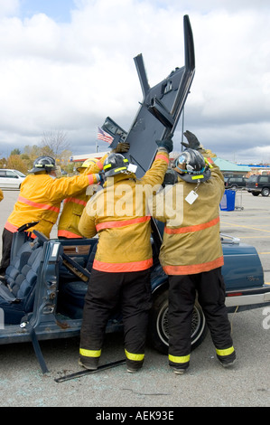 Fireman funziona con le ganasce della vita per estrarre la vittima di incidente automobilistico durante una sessione di formazione Foto Stock