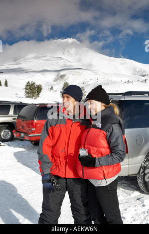 L uomo e la donna nel parcheggio di Timberline Lodge in inverno con il monte Cofano Foto Stock