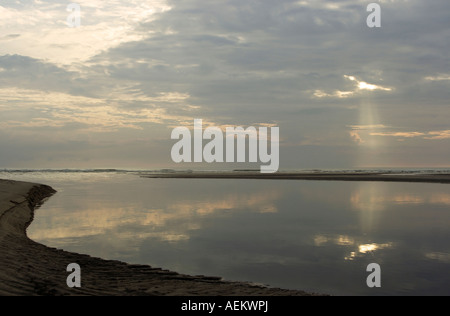 Acqua calma dietro il banco di sabbia la creazione di riflessione di sunray a sunrise. Foto Stock