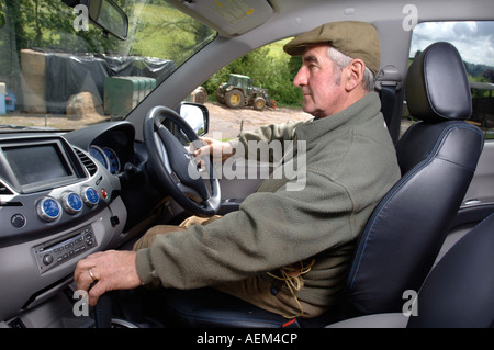 Ritratto di un Allevatore ovino NELLA CABINA DI UN QUATTRO A QUATTRO SU UN GLOUCESTERSHIRE FARM REGNO UNITO Foto Stock