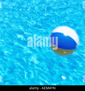 Palla spiaggia di essere soffiata attraverso una piscina Foto Stock