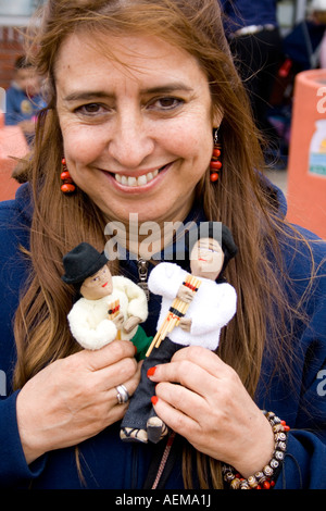 Fornitore ispanica età 34 tenendo gli uomini della montagna di bambole con i loro piccoli flauti di pan. Cinco de Mayo Fiesta. 'St Paul' Minnesota USA Foto Stock