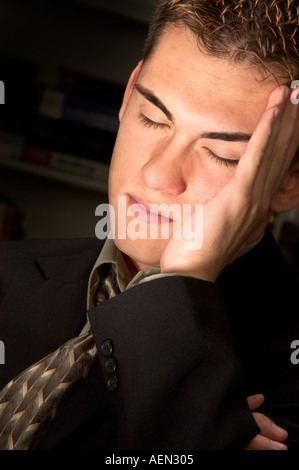 Emotivo, moody ritratto di ragazzo adolescente tenendo la sua testa Foto Stock