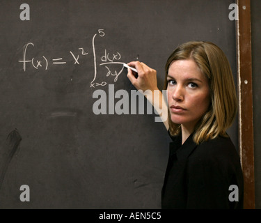 Insegnante di matematica la scrittura su una scheda di colore nero Foto Stock