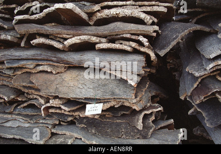 Grande pila di memorizzati querce da sughero in corteccia di albero. Appena raccolte, essiccazione all'esterno. Amorim cork impianto di produzione. Alentejo, Portogallo Foto Stock