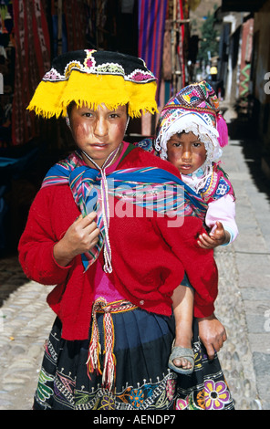 Ragazza giovane con la sorella sulla sua schiena, Pisac Market, Pisac, vicino a Cusco, Perù Foto Stock