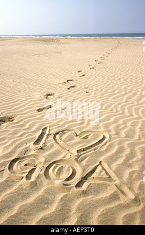 Goa in India I love Goa scritto in sabbia ondulata con la linea di orme Foto Stock