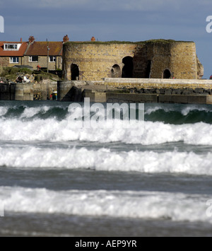 Beadnall Bay Harbor Northumberland con onde e il porto di Fort Foto Stock