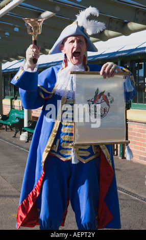 Town Crier in costume tradizionale, accogliendo i passeggeri in arrivo a un evento locale Foto Stock