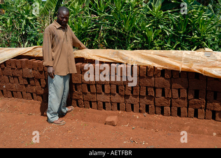 Uomo che mostra off mattoni essere sole asciugato nel Kenya occidentale in corrispondenza del lato di Kisumu Maseno strada in Kenya Africa orientale Foto Stock