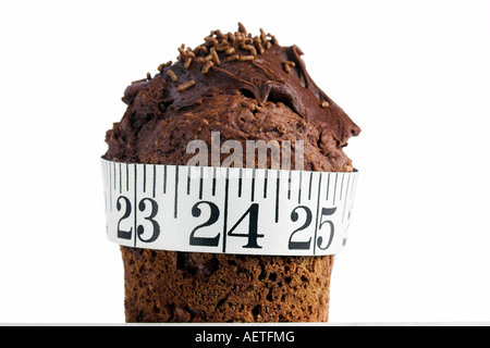 Colore orizzontale dell'immagine di una torta al cioccolato con un metro a nastro avvolto intorno ad esso Foto Stock