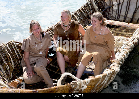 Le donne (MR) Neolitico pelle animale coperto coracle, piccole, arrotondato, leggero in barca a remi; Dinnet Festival, Moray Firth, Morayshire, Scotland Regno Unito Foto Stock