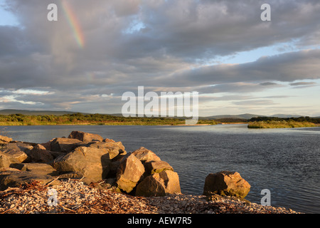 Rainbow sera luce del sole come tramonti a Spey Bay vegetated ghiaia alla foce del fiume Spey, Moray Firth, Inverness, Invernesshire Scozia, Regno Unito Foto Stock