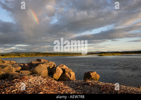 Rainbow sera luce del sole come tramonti a Spey Bay vegetated ghiaia alla foce del fiume Spey, Moray Firth, Inverness, Invernesshire Scozia, Regno Unito Foto Stock