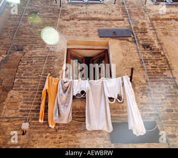 Donne appendere fuori il lavaggio a secco in San Gimignano Toscana Italia Europa Foto Stock