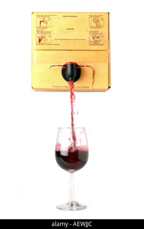 Vino rosso versato da una scatola in un wineglass Foto Stock