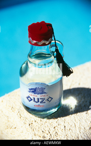 Ouzo la bevanda nazionale della Grecia aromatizzata con anice. Bottiglia e rabboccato con un cappuccio Scarlatto e nero tassel Foto Stock