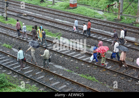 ANG71335 piogge monsoniche in Thane Maharashtra India mostrando persone che camminano sulla via ferroviaria treni n. Foto Stock