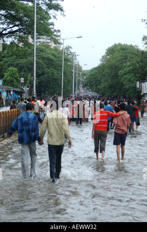Persone che camminano nella strada allagata piogge monsoniche a Bombay ora Mumbai India Foto Stock