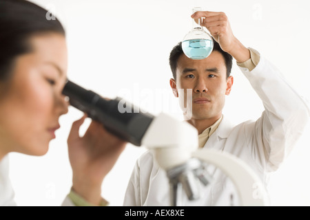 Gli scienziati con bicchiere e microscopio Foto Stock