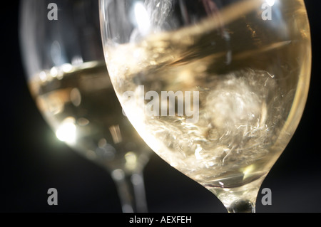 Vino bianco in bicchieri in una buia, sfondo nero Foto Stock