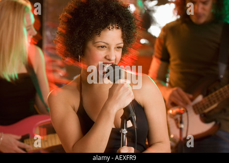 Donna cantare con una band Foto Stock