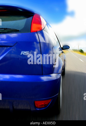 Vista posteriore verticale, formato immagine di un blu focus RS auto su una strada in movimento Foto Stock