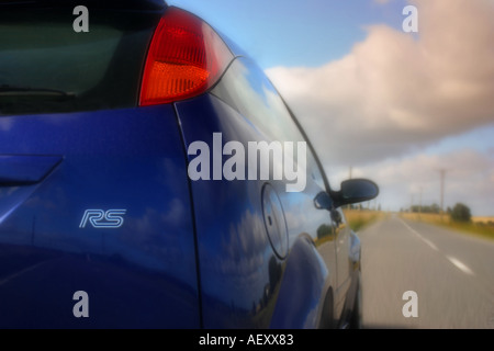 Vista posteriore orizzontale, formato immagine di un blu focus RS auto su una strada in movimento Foto Stock