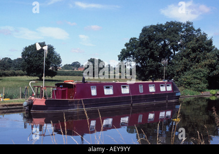 Liveaboard narrowboat con generatore a vento e TV montante su una zona residenziale di attracco, Shropshire Union Canal, vicino Brewood, Inghilterra Foto Stock