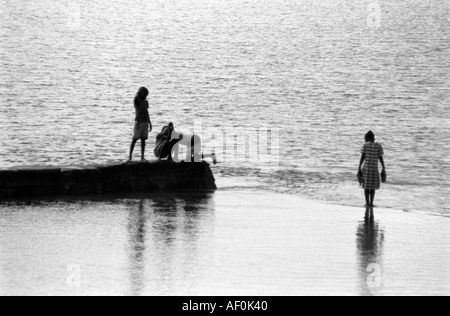 Locali di ragazzi e una ragazza giocare nel mare e sul mare parete Kenya Mombasa Foto Stock