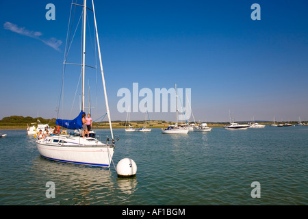 Persone che si rilassano a bordo di uno yacht a vela ormeggiato a Newtown Creek Isle of Wight Hampshire England UK Foto Stock