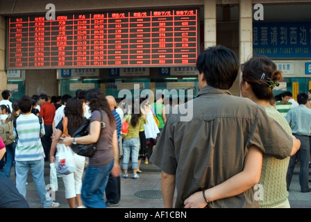 Pechino CINA, "stazione ferroviaria di Pechino » grande folla di persone che cercano, consulenza "orari" firma stazione ferroviaria coppia in piedi posteriore Foto Stock