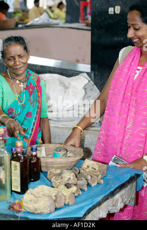 Nuovo Mercato in Margao Goa India Asia Goan indiano donna vendita di medicina ayurvedica radici tonici e fatti in casa elisir Foto Stock